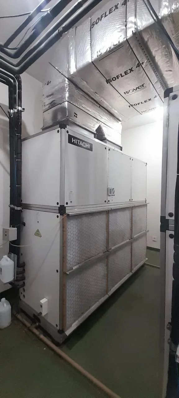 Casa de máquinas com equipamento de climatização de grande porte e dutos isolados