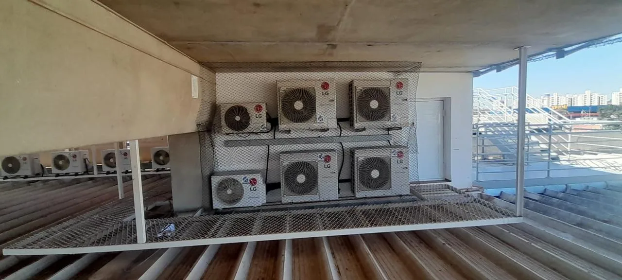 Condensadoras instaladas em rack metálico com proteção em obra corporativa